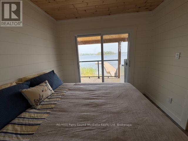 Primary Bedroom w. Walkout to covered porch - 1370 Georgian Bay Water, The Archipelago (Archipelago North), ON - Indoor Photo Showing Bedroom