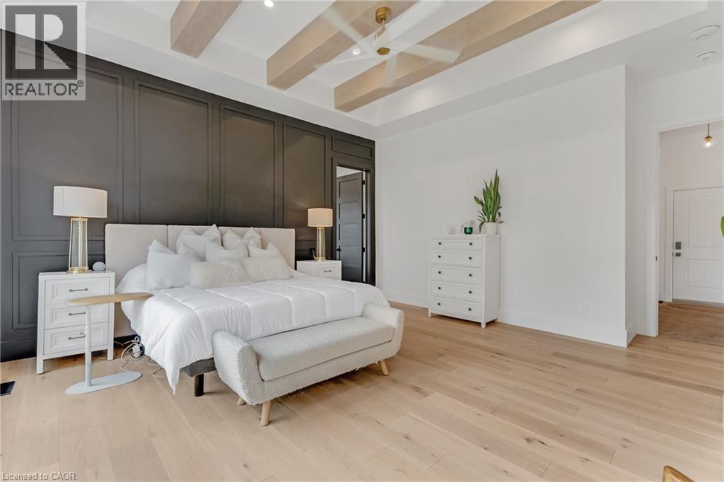Bedroom with light wood-style floors, beamed ceiling, and a decorative wall - 4678 Lobsinger Line, Crosshill, ON - Indoor Photo Showing Bedroom