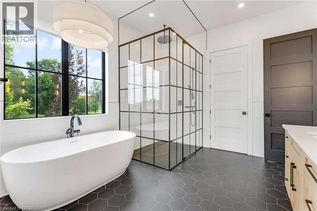 Full bath with a shower stall, a freestanding tub, vanity, tile walls, and tile patterned floors - 4678 Lobsinger Line, Crosshill, ON - Indoor Photo Showing Bathroom