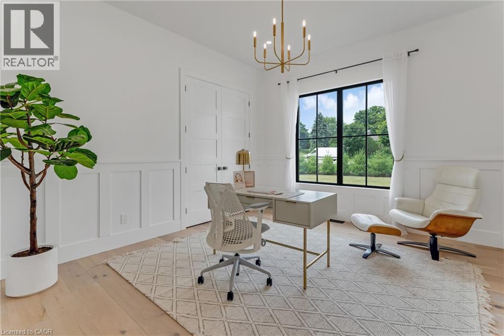 Office area featuring a decorative wall, wainscoting, a chandelier, and light wood finished floors - 4678 Lobsinger Line, Crosshill, ON - Indoor