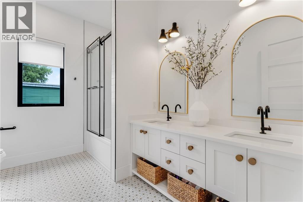 Bathroom featuring tile patterned floors, double vanity, and enclosed tub / shower combo - 4678 Lobsinger Line, Crosshill, ON - Indoor