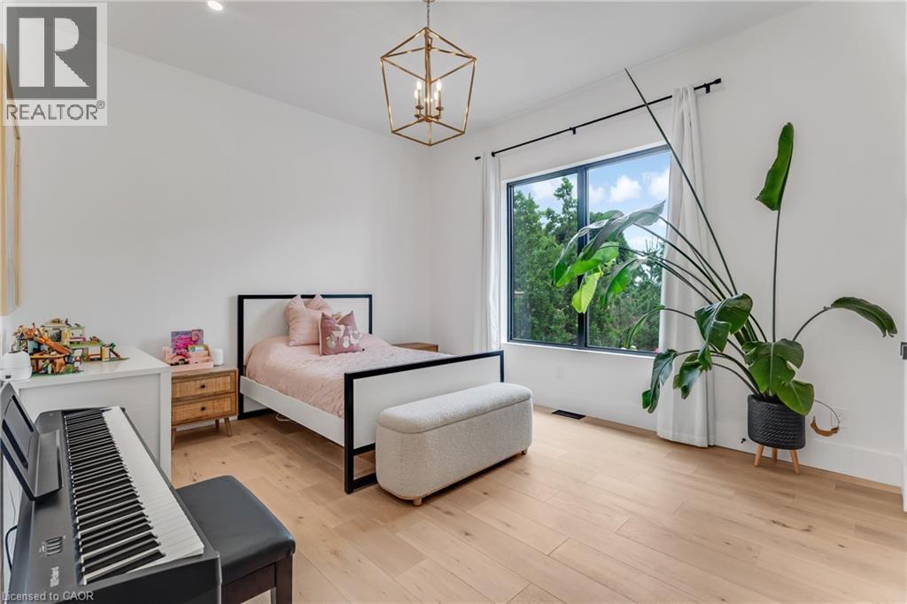 Bedroom with a chandelier and light wood-style floors - 4678 Lobsinger Line, Crosshill, ON - Indoor Photo Showing Bedroom