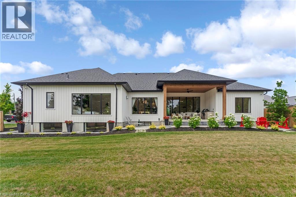 Rear view of house featuring ceiling fan, a lawn, a patio, and roof with shingles - 4678 Lobsinger Line, Crosshill, ON - Outdoor