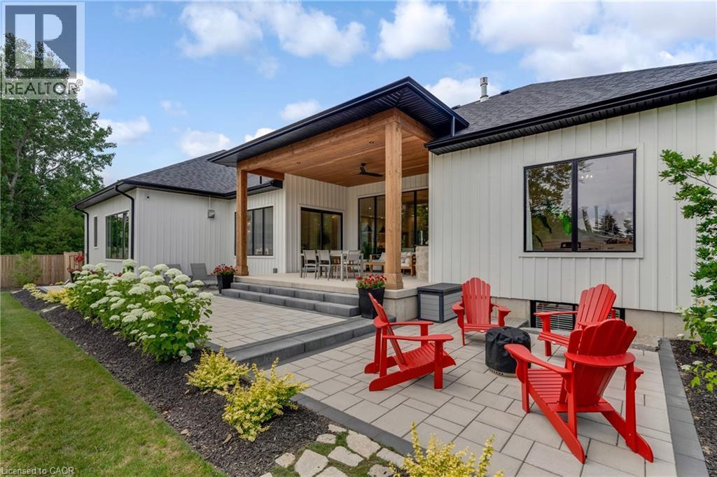 Rear view of property with an outdoor fire pit, a patio, a shingled roof, and a ceiling fan - 4678 Lobsinger Line, Crosshill, ON - Outdoor With Exterior