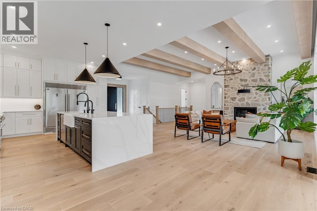 Kitchen with built in refrigerator, beamed ceiling, open floor plan, light wood-style flooring, and white cabinetry - 4678 Lobsinger Line, Crosshill, ON - Indoor Photo Showing Kitchen With Upgraded Kitchen