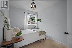 Bedroom with wood finished floors and a chandelier -