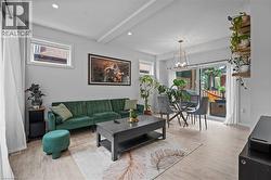 Living area with light wood finished floors, a chandelier, beamed ceiling, and recessed lighting -