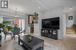 Living area featuring light wood-style floors, a chandelier, stairway, and recessed lighting -
