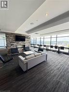 Living area featuring dark carpet, a fireplace, and healthy amount of natural light -