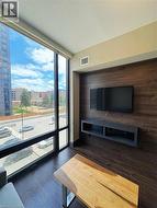 Unfurnished living room featuring wood finished floors, a textured ceiling, and a wall of windows -