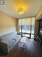 Living room featuring wood finished floors, a wall of windows, and a textured ceiling -