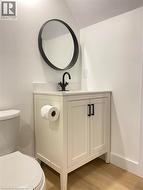 Half bathroom with wood finished floors and vanity -