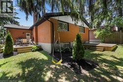 Rear view of house with a deck, brick siding, and a chimney -