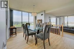 Dining area featuring light wood-type flooring, a chandelier, a textured ceiling, and floor to ceiling windows -