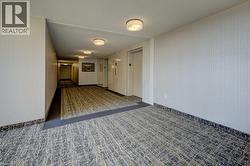 Corridor with carpet floors, elevator, and a textured ceiling -