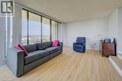 Living area featuring light wood-type flooring, a textured ceiling, and expansive windows -