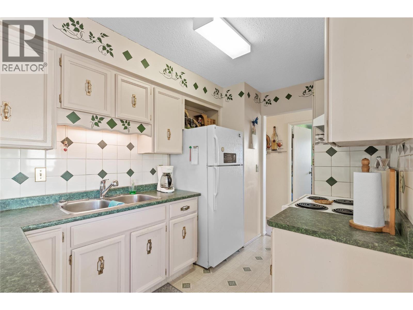 KITCHEN - Nice green countertops! - 3011 11 Street, Vernon, BC - Indoor Photo Showing Kitchen With Double Sink