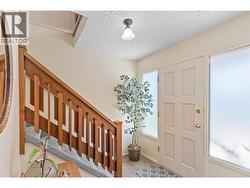 ENTRY HALLWAY - Nice wooden railings lead upstairs! -