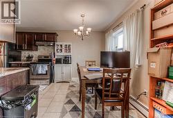 Dining room featuring light tile patterned flooring, a chandelier, and baseboard heating -