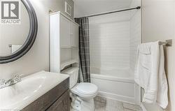 Full bathroom with shower / bath combo, light tile patterned floors, and vanity -