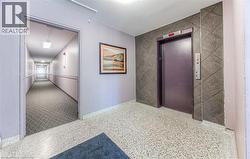 Corridor with elevator, tile walls, and an accent wall -