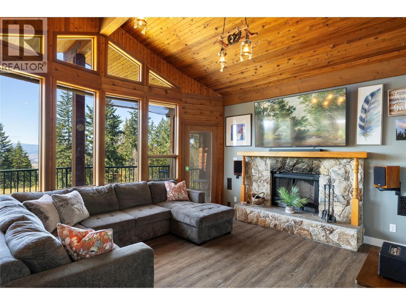Wood Fireplace - 7940 Keddleston Road, Vernon, BC - Indoor Photo Showing Living Room With Fireplace