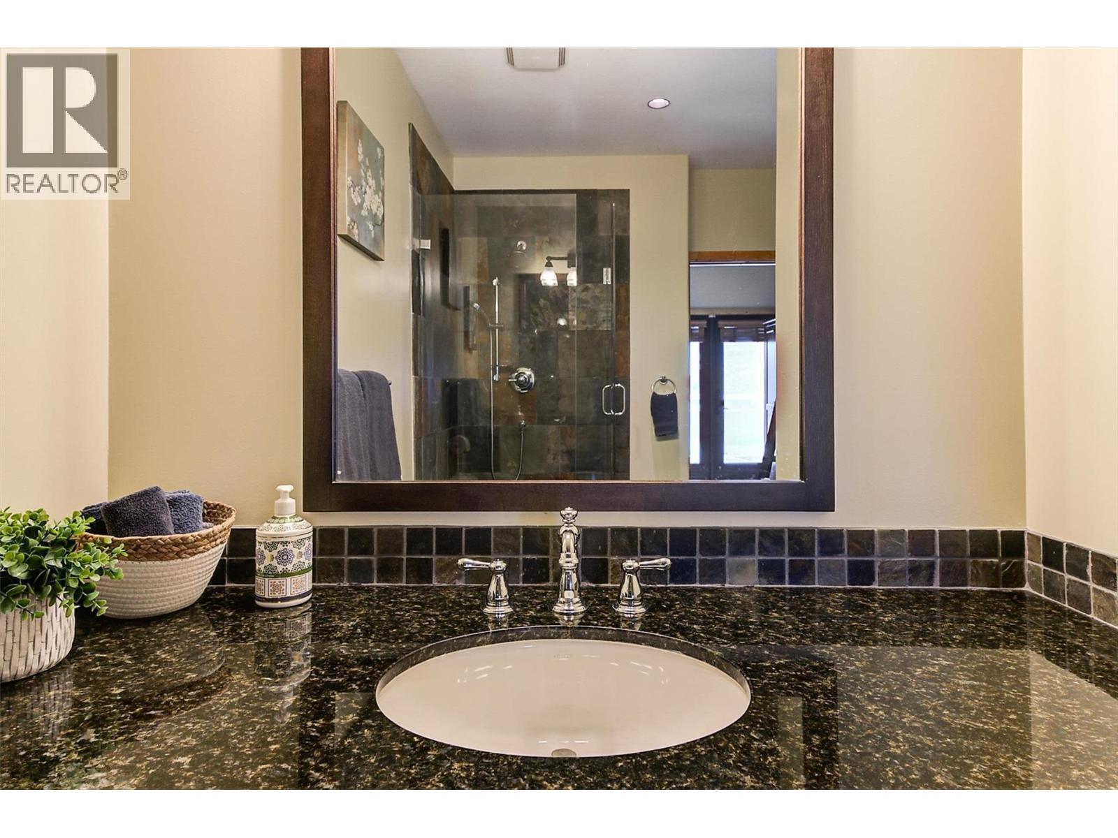 Granite counters and tile backsplash - 7172 Brent Road, Peachland, BC - Indoor Photo Showing Bathroom