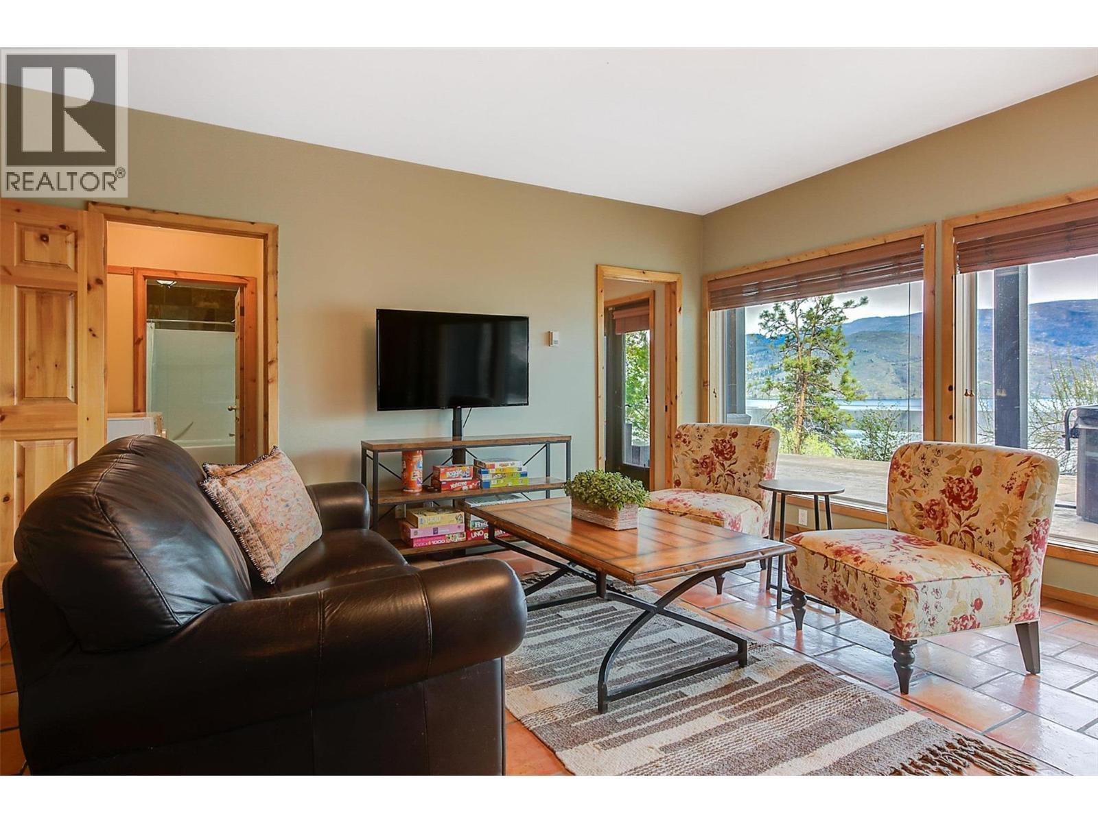 Enjoy the panoramic views of Okanagan Lake from the rec room! - 7172 Brent Road, Peachland, BC - Indoor Photo Showing Living Room