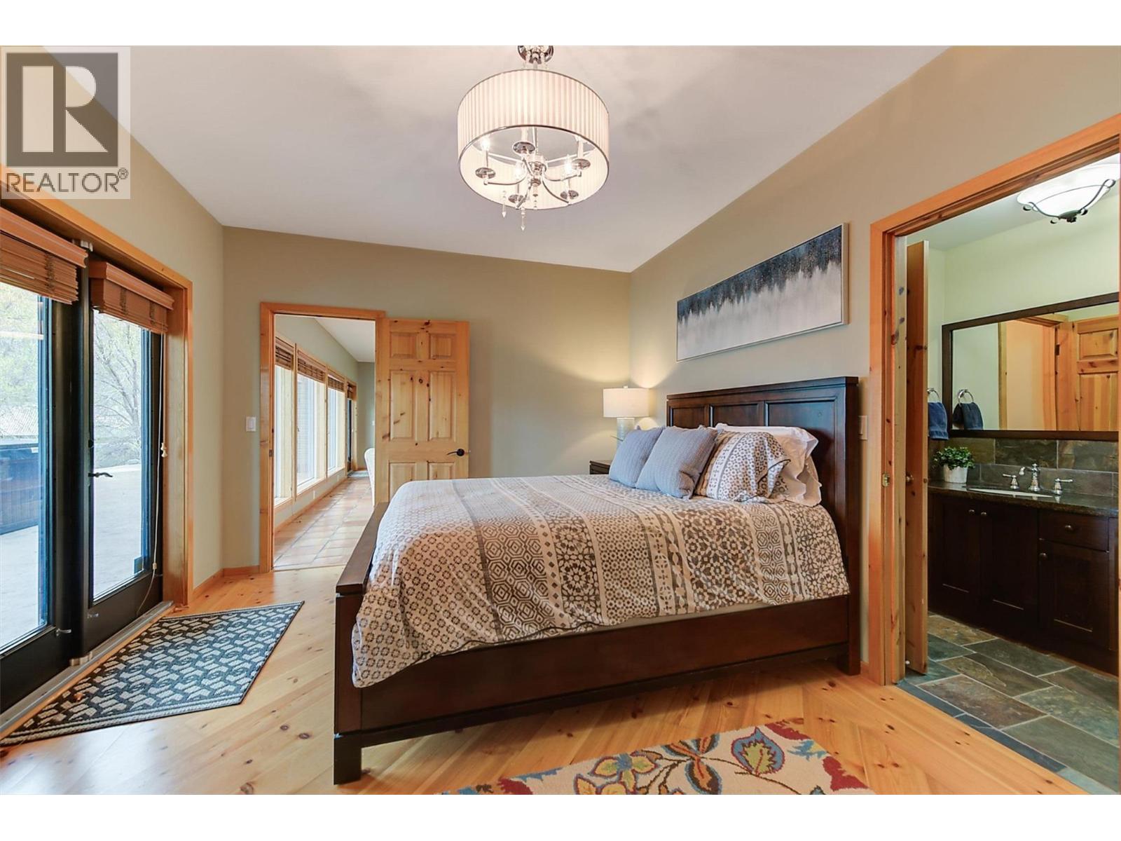 Walk-out access to lake view patio and hot tub! - 7172 Brent Road, Peachland, BC - Indoor Photo Showing Bedroom