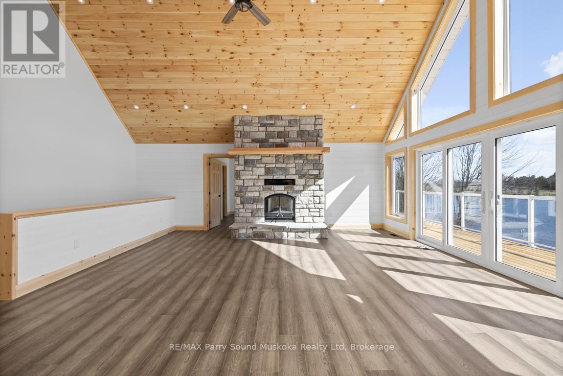 Floor to ceiling stone fireplace - 49 Hardies Road, Mckellar, ON - Indoor With Fireplace