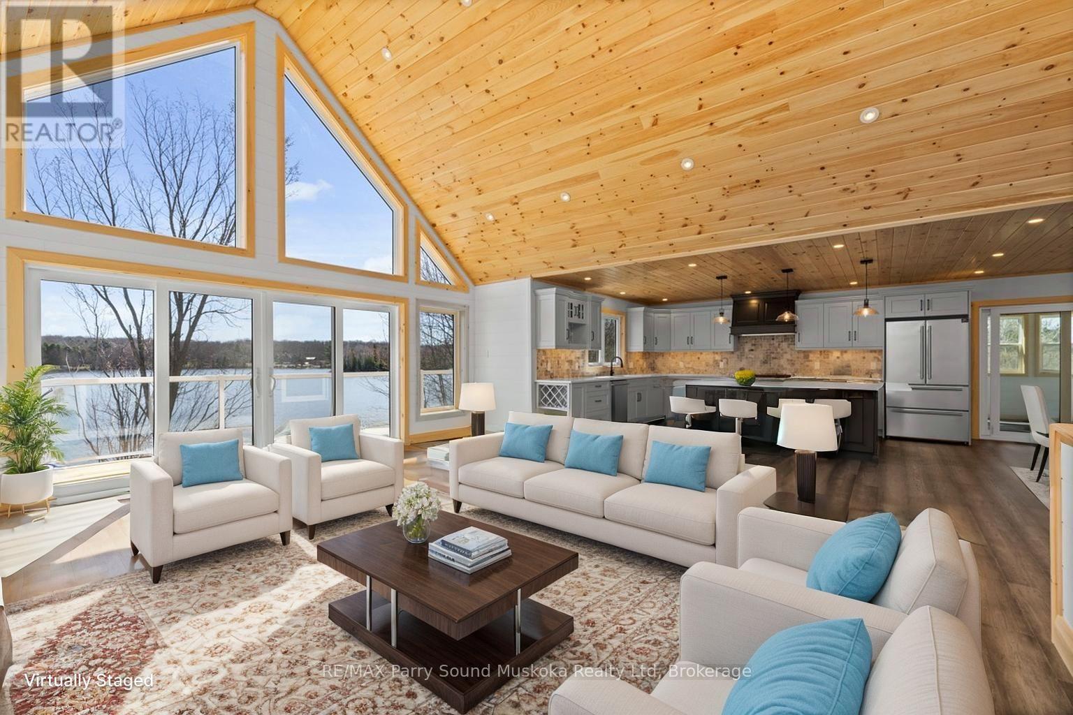 Wall of windows to enjoy lake views (v. staged) - 49 Hardies Road, Mckellar, ON - Indoor Photo Showing Living Room