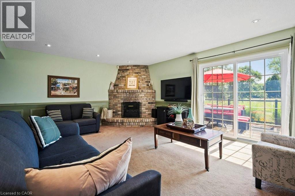 Living area with carpet floors, a fireplace, a textured ceiling, recessed lighting, and a wainscoted wall - 3 Meadowbrook Court, St. George, ON - Indoor Photo Showing Living Room With Fireplace