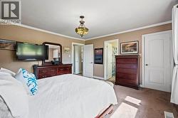 Bedroom with crown molding, carpet floors, and ensuite bathroom -
