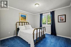 Bedroom featuring ornamental molding, carpet, and a textured ceiling -