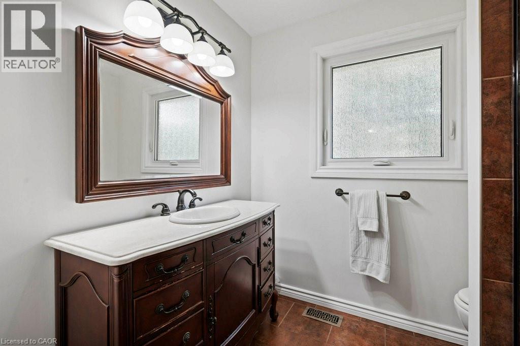 Bathroom featuring vanity and dark tile patterned floors - 3 Meadowbrook Court, St. George, ON - Indoor Photo Showing Bathroom