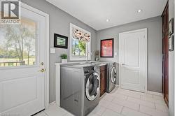 Laundry area featuring light tile patterned floors, washing machine and dryer, and recessed lighting -