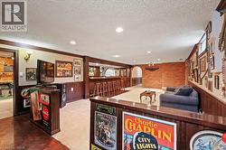 Playroom with wainscoting, a textured ceiling, ornamental molding, wooden walls, and wood finished floors -
