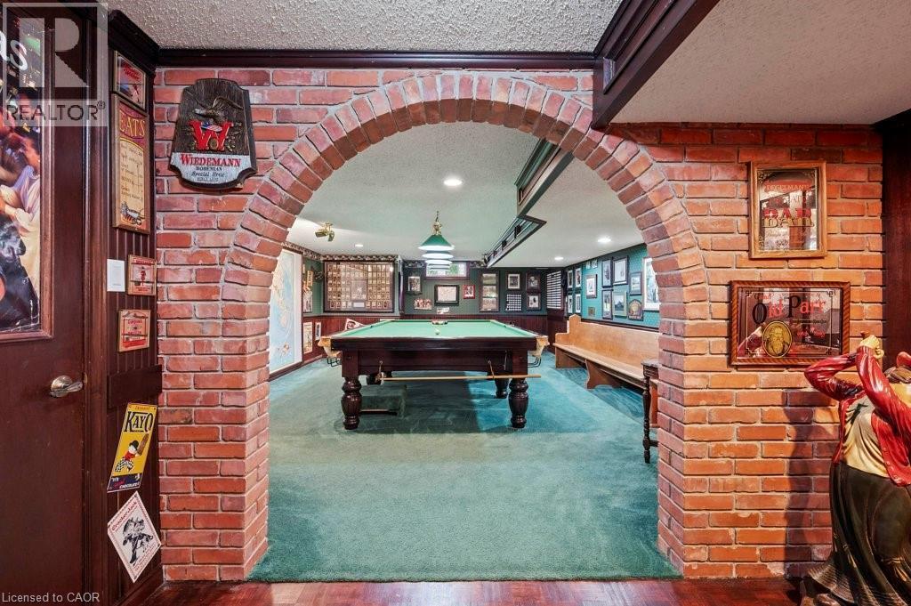 Rec room featuring arched walkways, carpet flooring, pool table, a textured ceiling, and brick wall - 3 Meadowbrook Court, St. George, ON - Indoor Photo Showing Other Room