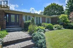 Doorway to property featuring brick siding and a yard -