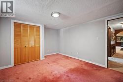 Unfurnished bedroom with a textured ceiling, carpet flooring, a closet, and arched walkways -