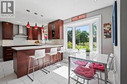 Kitchen featuring a breakfast bar area, plenty of natural light, decorative light fixtures, decorative backsplash, and recessed lighting -
