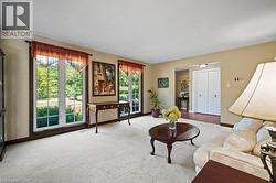 Living room featuring carpet and baseboards -