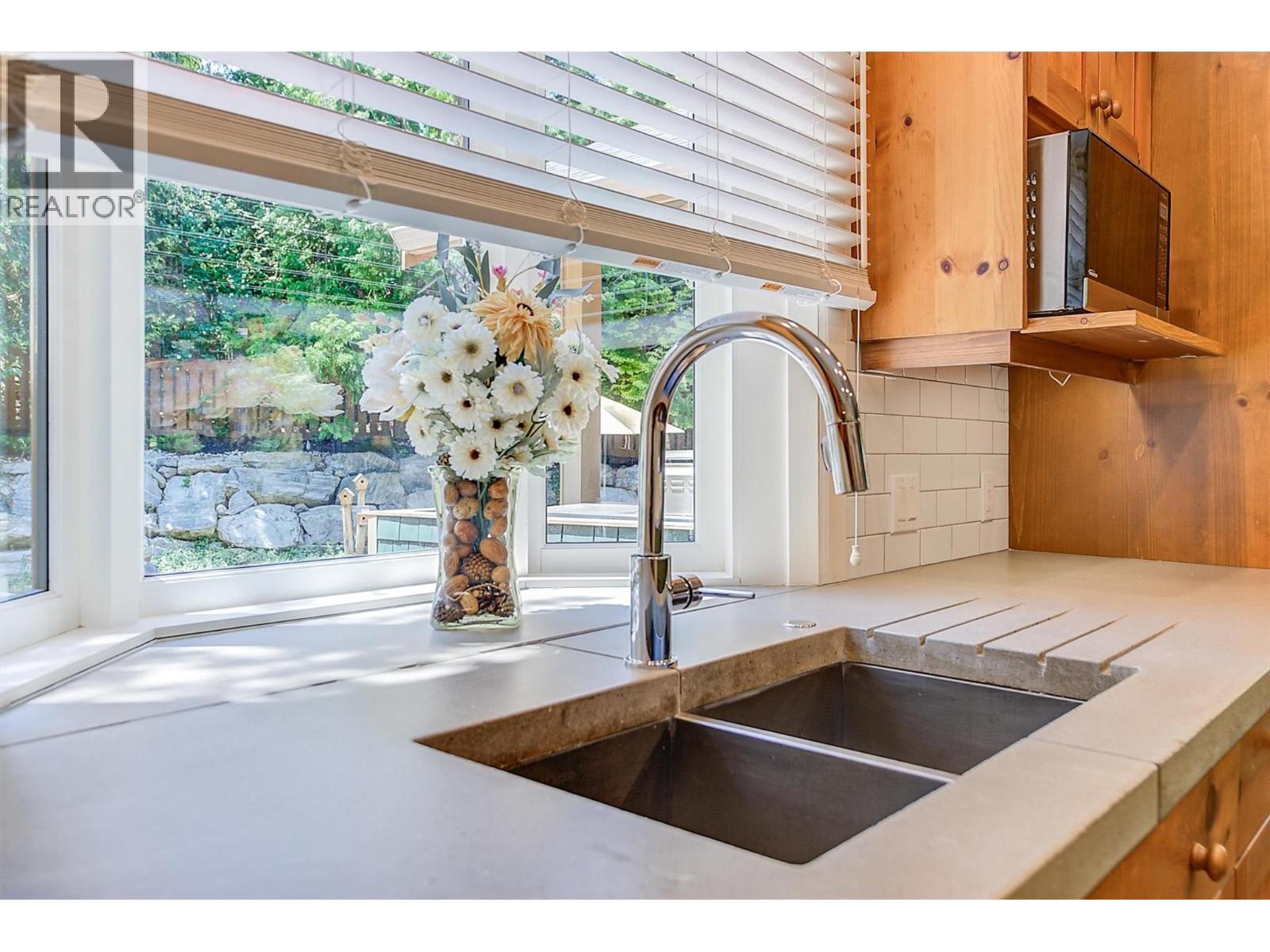 Enjoy views to the yard from the kitchen sink - 5127 Luckett Court, Kelowna, BC - Indoor Photo Showing Kitchen With Double Sink