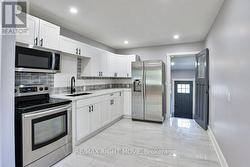 Ceramic tiled floor; stainless steel appliances. -