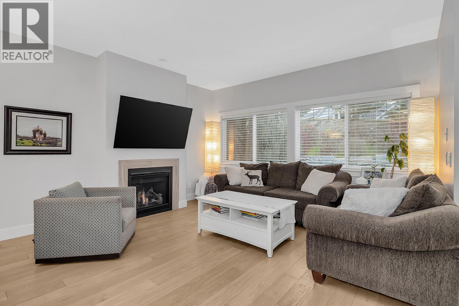 Cozy living room with ample natural lighting! - 1450 Union Road Unit# 41, Kelowna, BC - Indoor Photo Showing Living Room With Fireplace