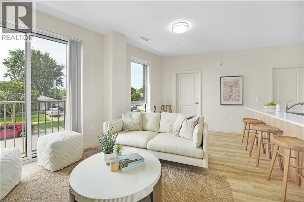 Living area with light wood-style floors and baseboard heating - 301 Westmount Road W Unit# 205, Kitchener, ON - Indoor Photo Showing Living Room