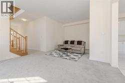 Living room featuring light colored carpet and stairway -