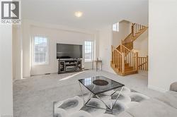 Carpeted living room with a fireplace and stairs -