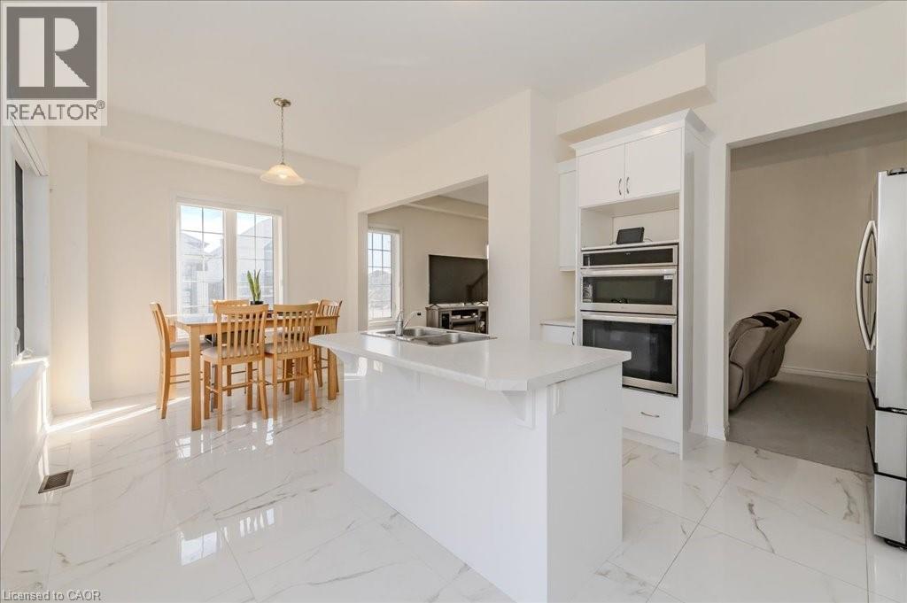 Kitchen with light countertops, white cabinets, light marble finish flooring, and pendant lighting - 35 Hitchman Street, Paris, ON - Indoor