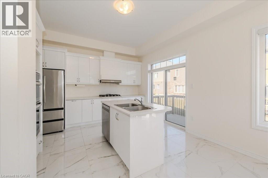 Kitchen featuring an island with sink, light marble finish flooring, light countertops, and stainless steel appliances - 35 Hitchman Street, Paris, ON - Indoor Photo Showing Kitchen With Double Sink